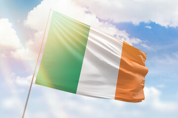 Sunny blue sky and a flagpole with the flag of ireland