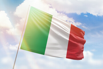 Sunny blue sky and a flagpole with the flag of italy