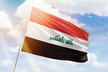 Sunny blue sky and a flagpole with the flag of iraq