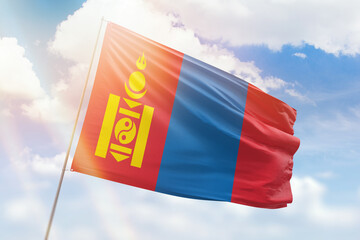 Sunny blue sky and a flagpole with the flag of mongolia