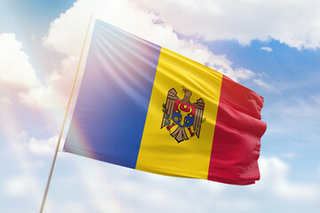 Sunny blue sky and a flagpole with the flag of moldova