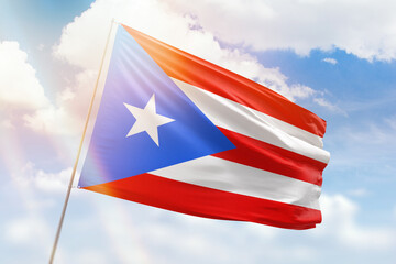 Sunny blue sky and a flagpole with the flag of puerto rico