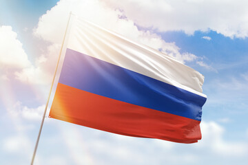 Sunny blue sky and a flagpole with the flag of russia