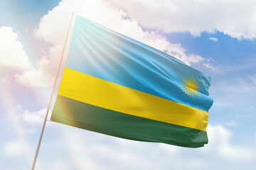 Sunny blue sky and a flagpole with the flag of rwanda