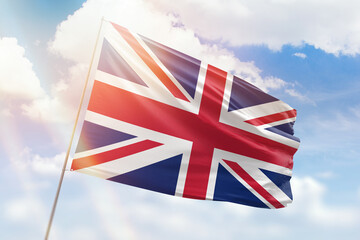 Sunny blue sky and a flagpole with the flag of united kingdom