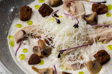A bowl of Mushroom Cream Soup with fried champignons and chicken. Winter, autumn hot soup concept