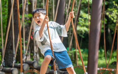 アスレチックで遊ぶアジア人の男の子