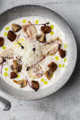 A bowl of Mushroom Cream Soup with fried champignons and chicken. Winter, autumn hot soup concept