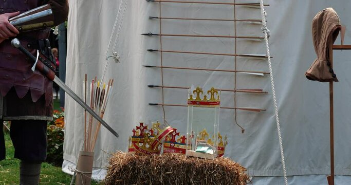 various medieval weapons on a haystack next to a tent