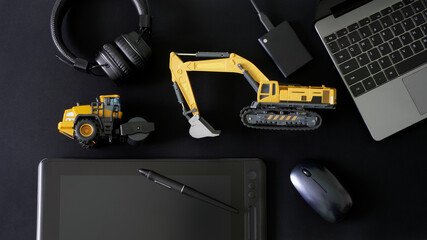 Stylus, graphics tablet, mouse, laptop, ssd drive and headphones next to models excavator and...