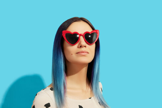 Hipster woman with blue hair wearing sunglasses. Happy caucasian girl looking up