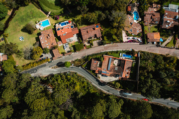 Aerial view with a drone of street in Avandaro in Valle de Bravo surrounded by trees.