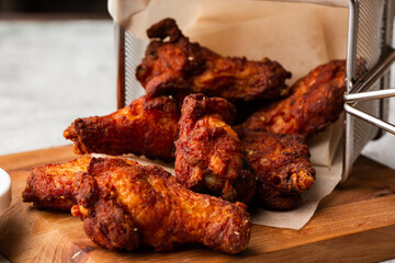 Fried Chicken Wings Covered in True Hot BBQ Sauce served with red hot chilli sauce on a Cutting Board on marble background.