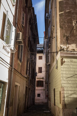 Typical mediterranean old narrow street with southern european architecture, with ancient buildings with balconies, in the old town of piran or Pirano one of the main cities of Istria, on Adriatic sea
