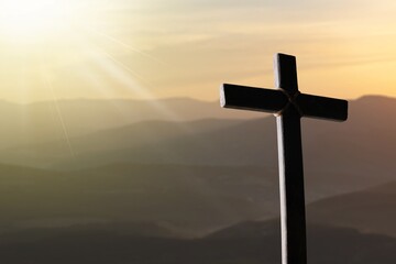 A christian cross at a scenic sunset or sunrise