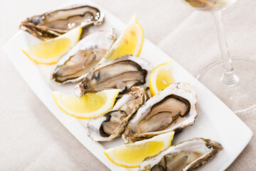 Seafood. Delicious raw fresh oysters served on white plate with lemon..