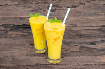 Mango juice fruit smoothies yogurt drink yellow healthy delicious taste in a glass slush for weight loss on wooden background.