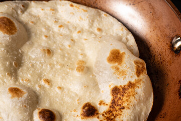 Cooking Tandoori Roti in frying pan, a typical flatbread and popular in West, Central and South Asia.