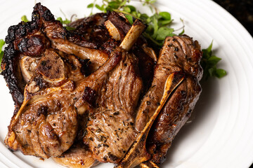 Cooked lamb loin chops with rosemary in a plate.