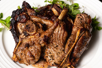 Cooked lamb loin chops with rosemary in a plate.