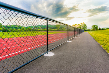Low perspective image from outside new running track looking toward perimeter fence and horizon