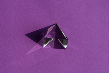 Crystal prism refracting light, magic crystals and pyramid, sphere and cube on purple background....