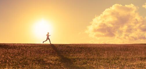Fototapeta na wymiar Fit male running in field at sunrise