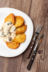 Pancakes with fried mushrooms and onions. Potato pancakes with mushrooms and sour cream. Ukrainian cuisine, European cuisine