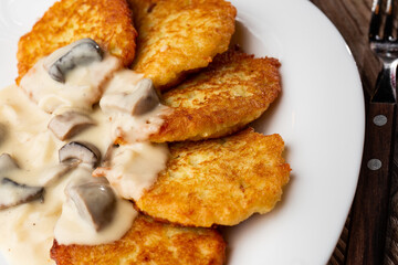 Pancakes with fried mushrooms and onions. Potato pancakes with mushrooms and sour cream. Ukrainian cuisine, European cuisine