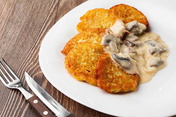 Pancakes with fried mushrooms and onions. Potato pancakes with mushrooms and sour cream. Ukrainian cuisine, European cuisine