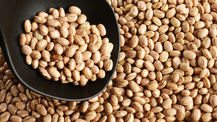 Ladle of carioca beans on the beans background.