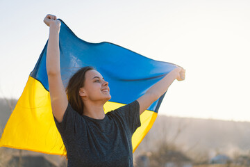 Woman holding a yellow and blue flag of Ukraine in outdoors. Independence Day. Flag Day....