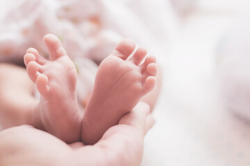 Obraz na płótnie Canvas Baby feet on parent hands