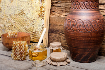 fresh bee honey in  glass jar with a honey dipper on  wooden background.