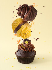 Falling chocolate cupcakes on light color background
