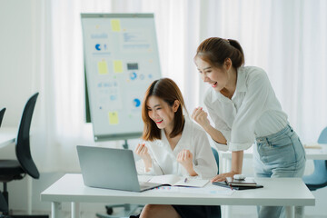 Two young Asian businesswomen discuss business in a meeting room brainstorming for a successful start in a modern office.