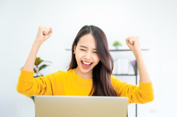 Excited female feeling euphoric celebrating online win success achievement result, young asian...
