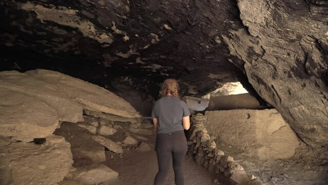 Female hiker tours Gila Cliff Dwellings National Monument, New Mexico