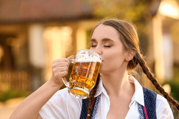 German woman with beer celebrating Octoberfest outdoors