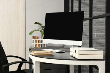 Modern computer and notebooks on table in office