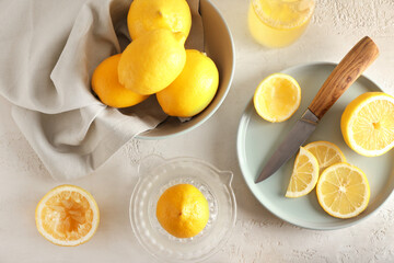 Composition with ripe lemons and juicer on light background