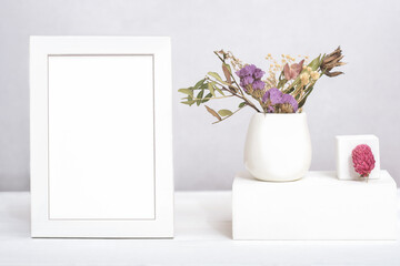 white frame with copy space and dry flowers ina vase on geometric podium or pedestal. template for text or inscription. mock up for sale advertisment or inspirational card