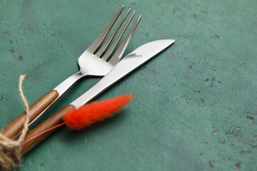 Knife and fork with floral decor on green background