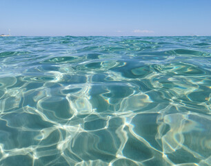  Crystal clear, blue, transparent water of the Mediterranean Sea on Sunrise beach.