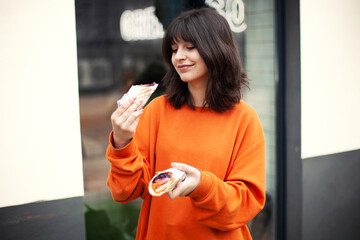 A young smiling girl holds vegetarian rolls.