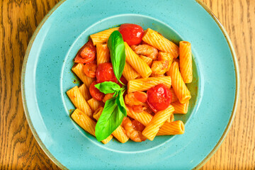 Italian recipe Pasta tortilloni with green pea, mint leaves, cheece, smoked bacon and cheese. Top view, blue background