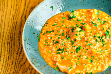Tomato Risotto on a white restaurant plate.
