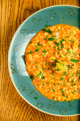 Tomato Risotto on a white restaurant plate.