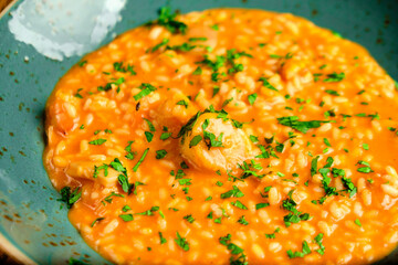 Tomato Risotto on a white restaurant plate.