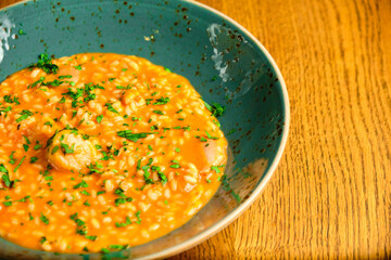 Tomato Risotto on a white restaurant plate.
